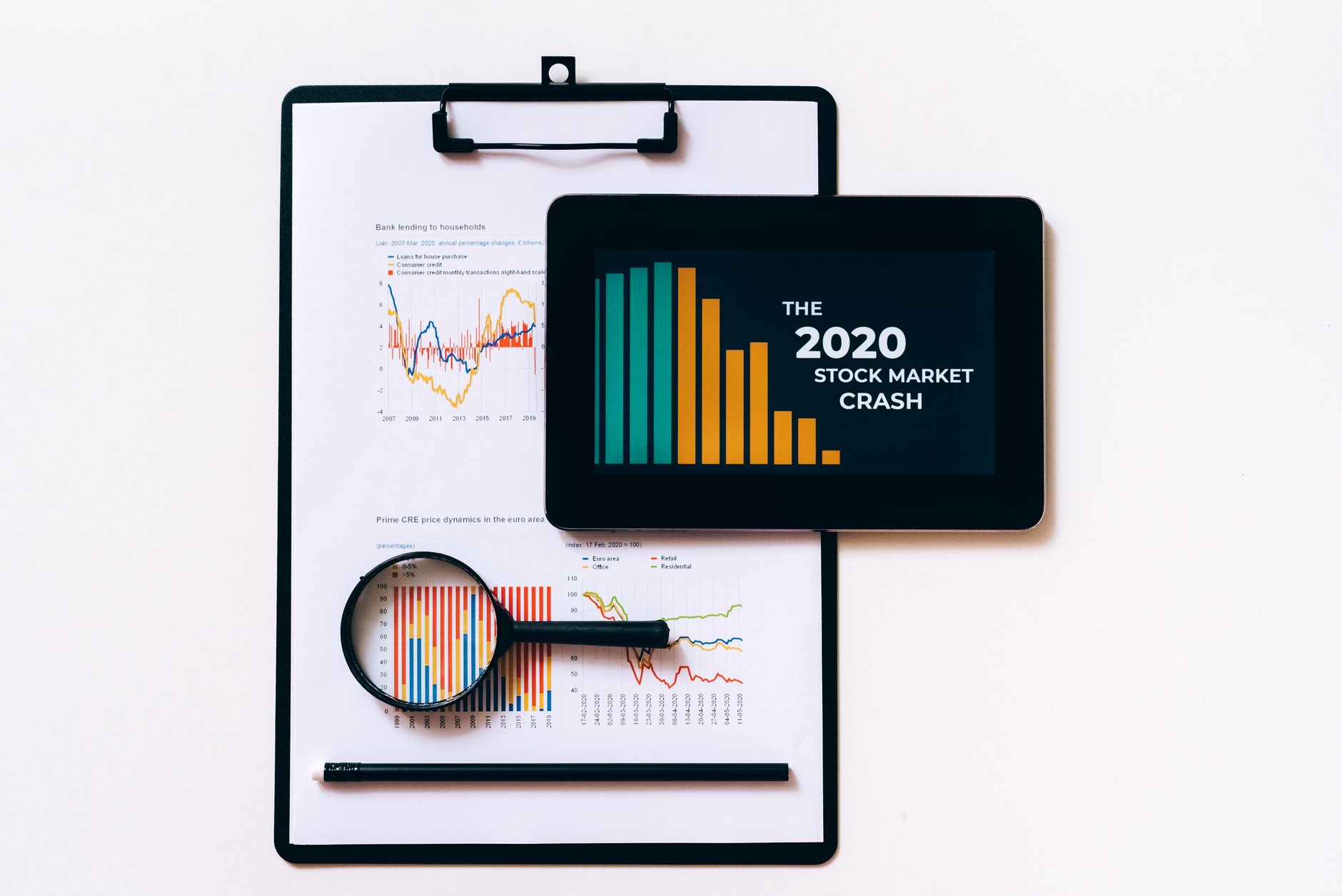 Tablet and clipboard with charts illustrating the 2020 stock market crash.