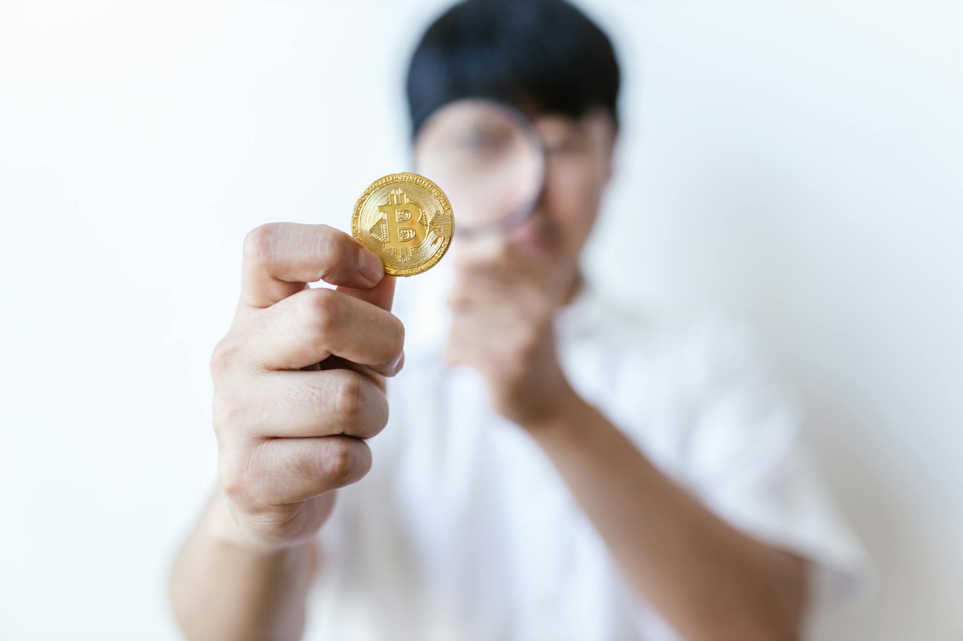 A person holds a bitcoin coin, highlighting its importance and value.