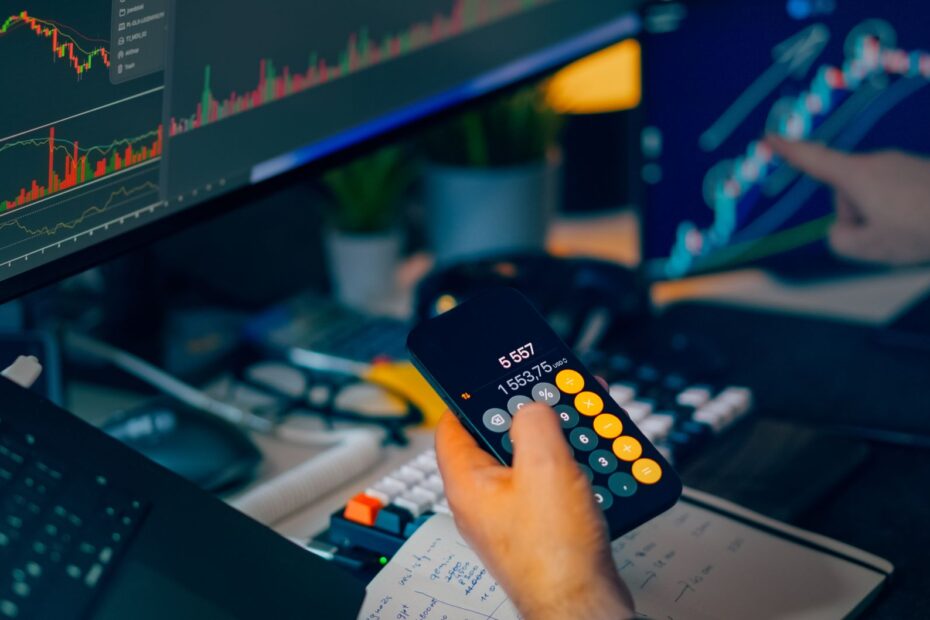 A person working at a desk with multiple monitors displaying cryptocurrency charts and data.