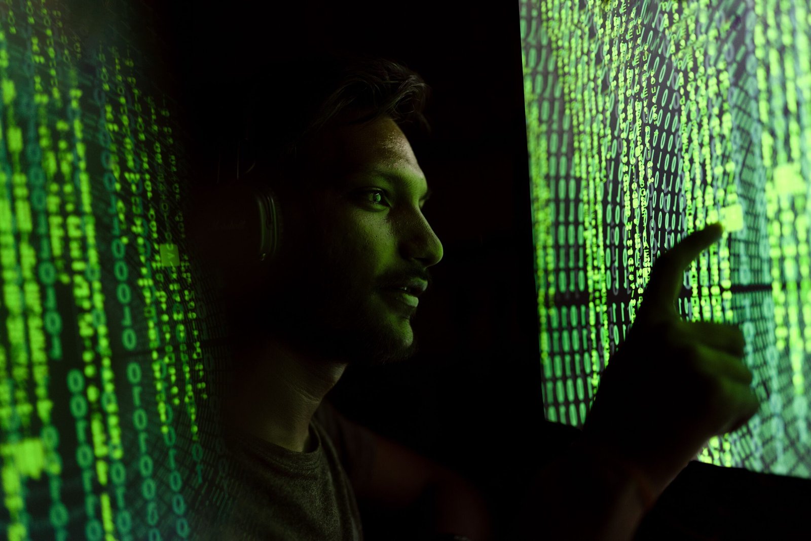A person interacts with digital code on a screen, symbolizing cybersecurity technology.