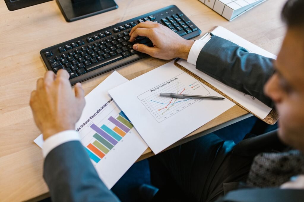 A person focused on a laptop with abstract digital asset charts in the background, symbolizing adaptive productivity in a dynamic financial environment.