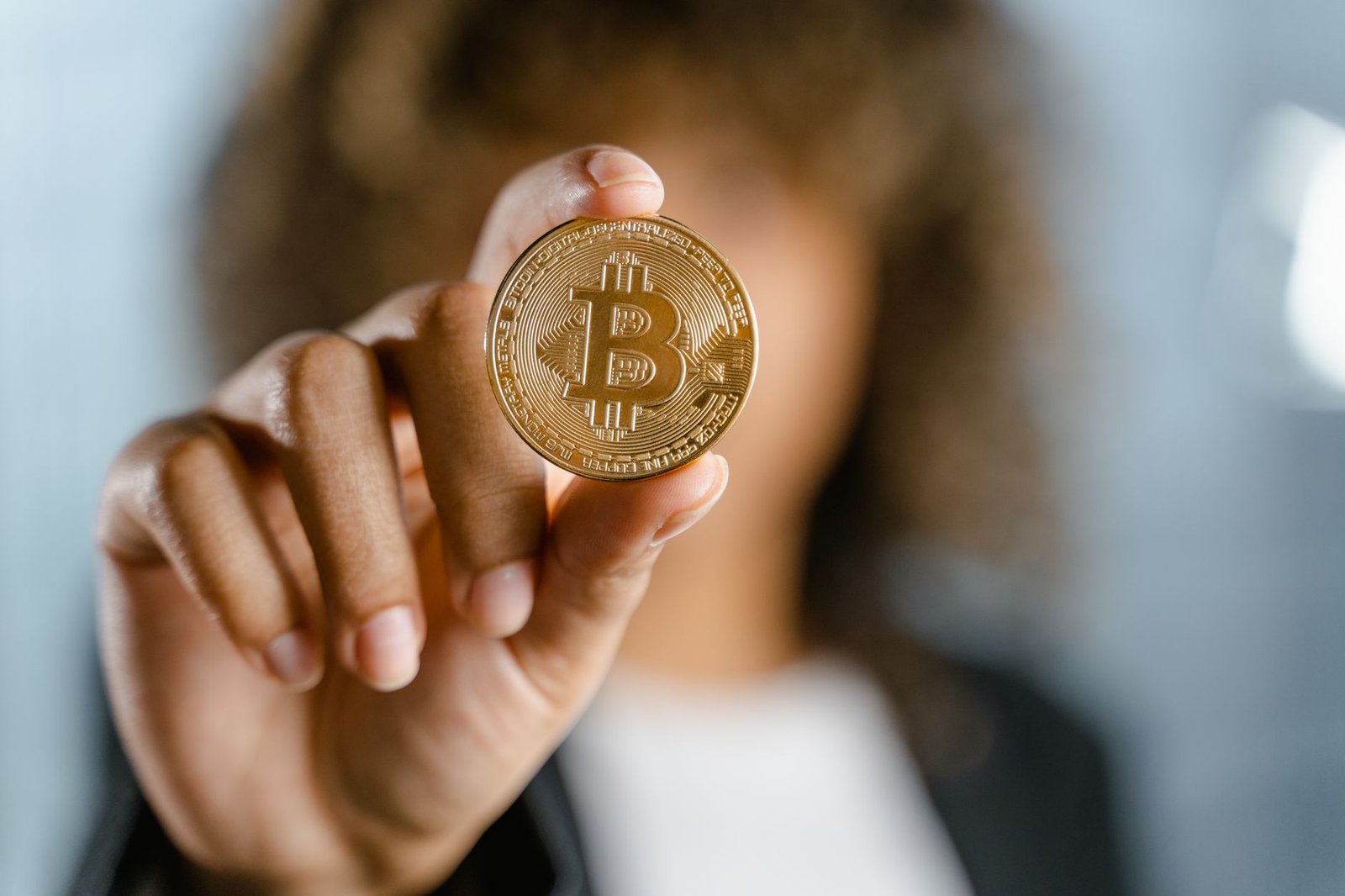 Close-up of a person holding a Bitcoin, symbolizing cryptocurrency and digital finance.